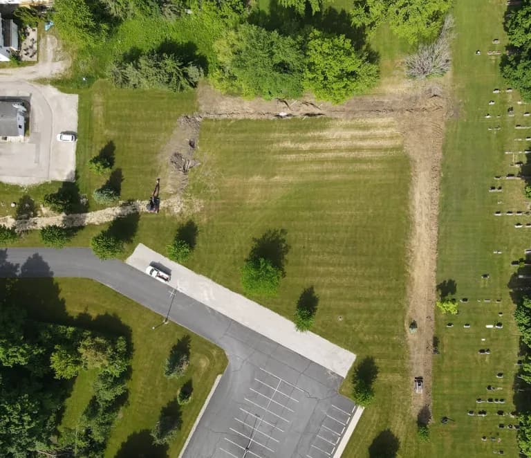 Aerial view of a Brady drainage trench installation running across a green field