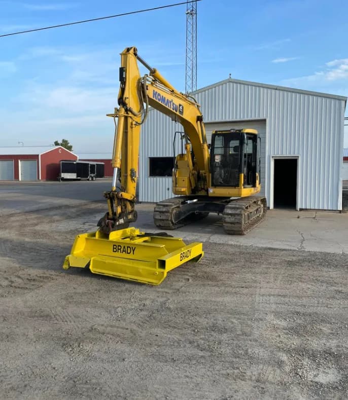 Brady Komatsu excavator with custom Brady grading attachment at the Tecumseh shop